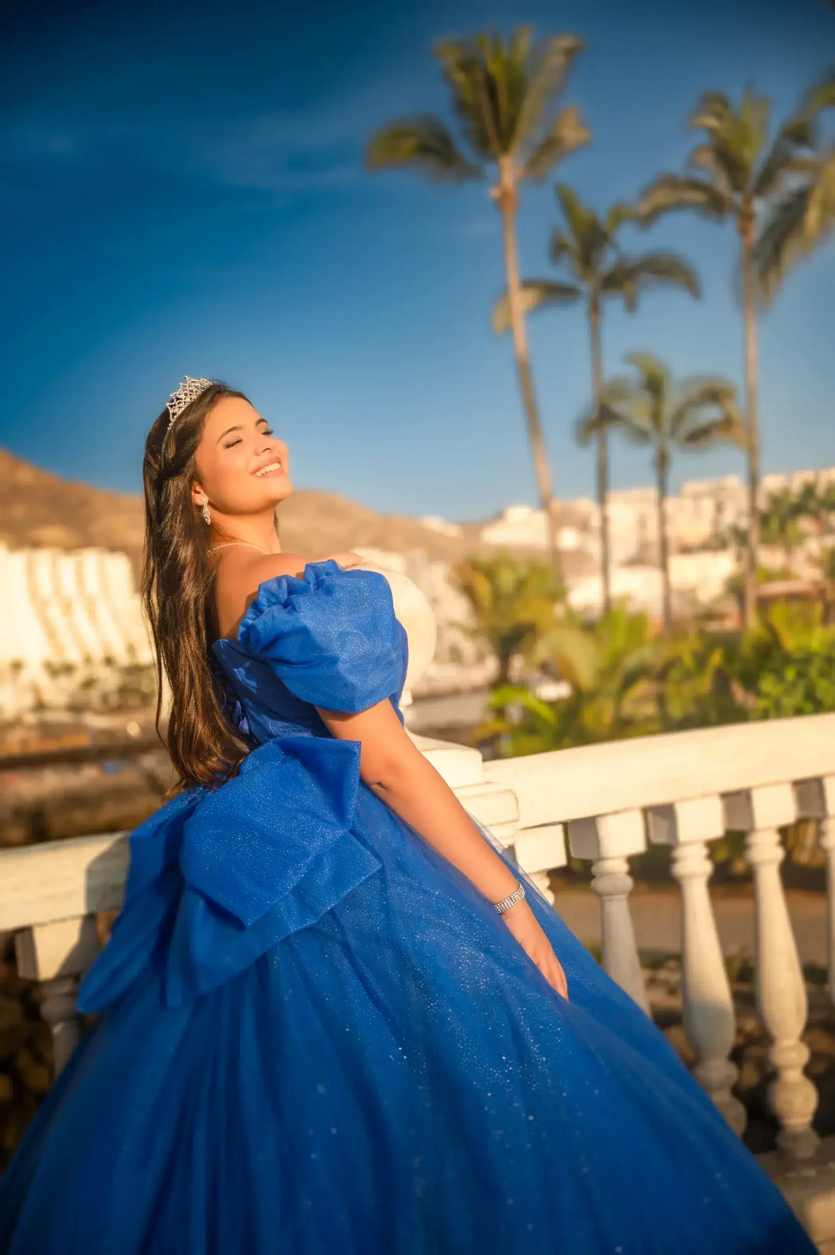 Joven con corona y vestido azul en una sesión de quince años.